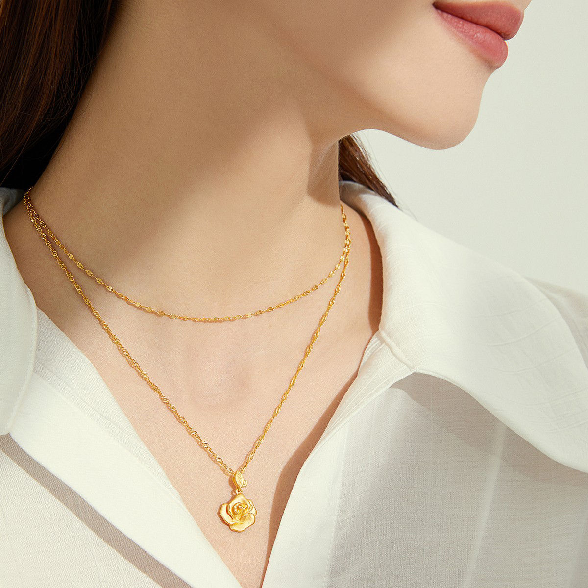 The delicate golden sheen of a gold necklace perfectly complements a deep V neckline.