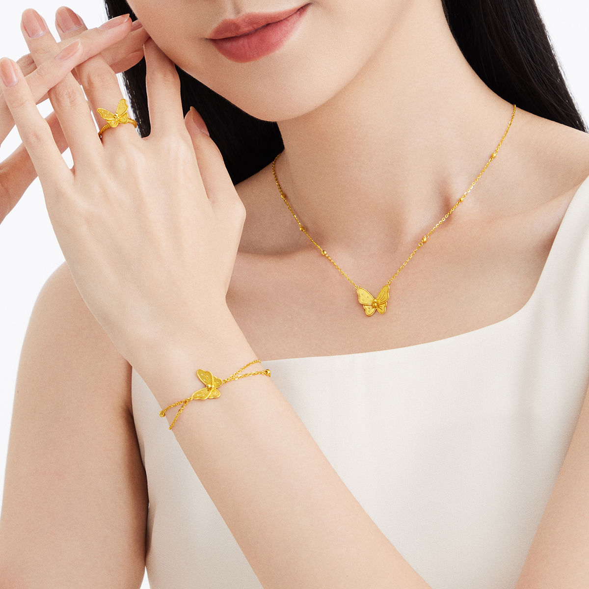 Wear a butterfly-themed gold jewellery set, including a necklace, bracelet, and ring, symbolizing elegance and femininity.